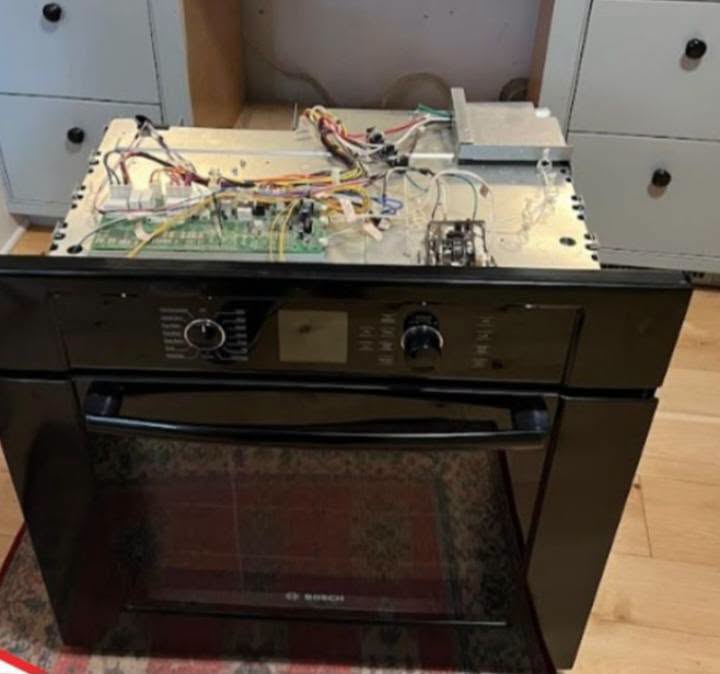 Oven control board exposed for repair