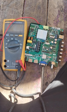 Multimeter testing a circuit board